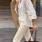 White blouse with a V-neckline and openwork sleeves