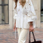 White blouse with a V-neckline and openwork sleeves
